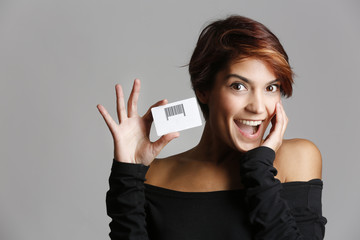 Bella ragazza dal viso sbarazzino esibisce entusiasta carta sconto