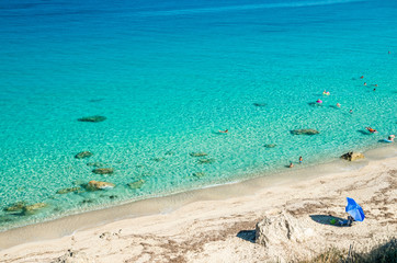 Obraz premium Agios Nikitas beach in Lefkada Island, Greece - Ionian Islands. In the background it is visible the village of Agios Nikitas. The beach is near the village of Agios Nikitas.