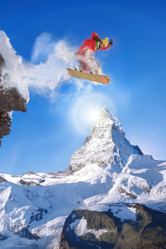 Snowboarder jumping against Matterhorn peak in Switzerland