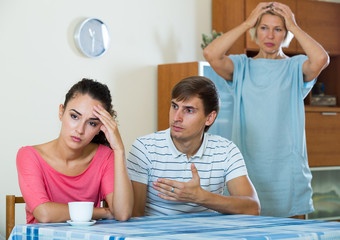 Elderly mother and young man blaming girl in something
