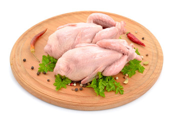 Quail meat on the round board. Isolated on white background.
