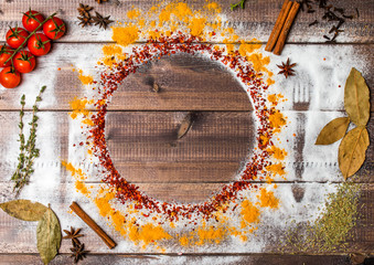 Spices on wooden table with cutlery silhouette
