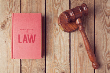 Law book and gavel on wooden background. Justice concept