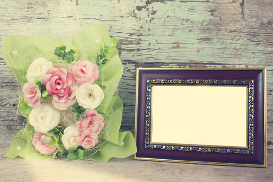 rose in vase and frame of wooden background