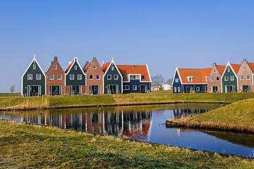 Colored houses of marine  park in Volendam reflected in the water, The Netherlands