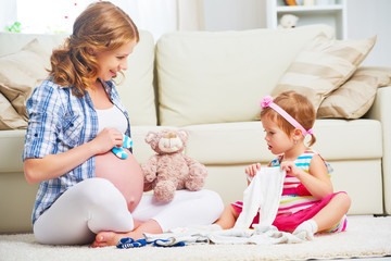 happy family pregnant mother and child preparing clothing for ne