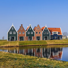 Colored houses of marine  park in Volendam reflected in the water, The Netherlands