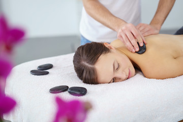 Obraz na płótnie Canvas attraktive frau entspannt bei einer hot stone massage