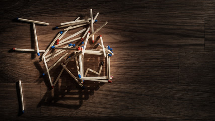 Overturned matches tower with burned match inside symbolising helpless human being.