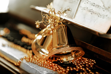 Piano keys decorated with golden Christmas decorations, close up