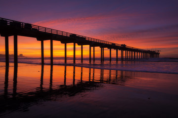 Fototapeta na wymiar Silhouette pier at beach and brilliant sunset