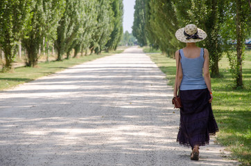 Ragazza con il cappello che cammina nel parco