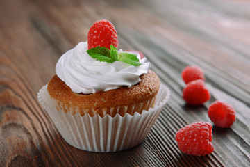 Delicious cupcake with berries and fresh mint on wooden table close up