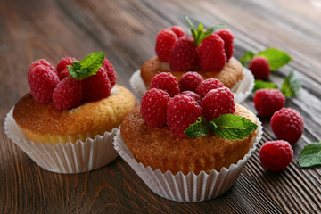 Delicious cupcakes with berries and fresh mint on wooden table close up