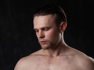 Naklejka premium Portrait of a naked muscular guy on a gray background