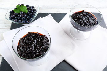 Tasty currant jam with berries on table close up