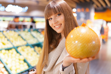 Woman holding pomelo at supermarket