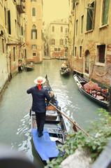 Fototapeta na wymiar Vintage image of a gondolier on the canal in Venice city, Italy