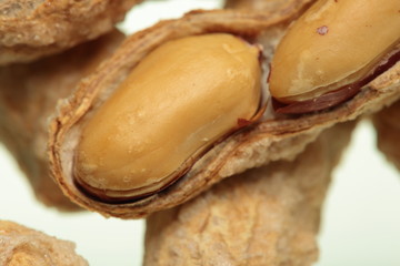 salted peanuts on white background
