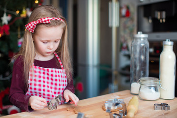 Little adorable girl baking Christmas cookies at home