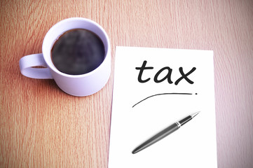 Coffee on the table with note writing writing tax