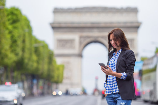 Beautiful woman holding a phone on the Champs Elysees in Paris