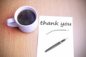 Coffee on the table with note writing writing thank you