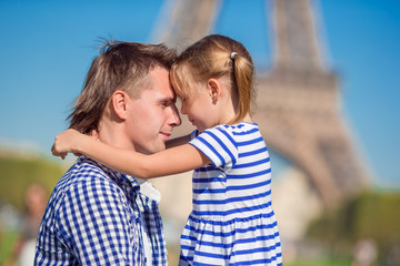 Fototapeta premium Happy family near Eiffel Tower in Paris, France