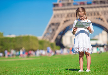 Adorable little girl with map of Paris background the Eiffel tower