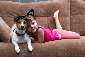 little girl with cat face painting embrace her dog