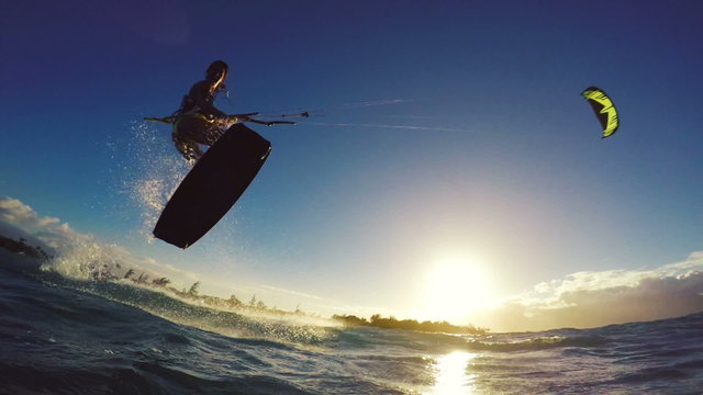 Extreme Kitesurfing at Sunset. Summer Ocean Sport in Slow Motion. Girl Kite Surfing in Bikini 