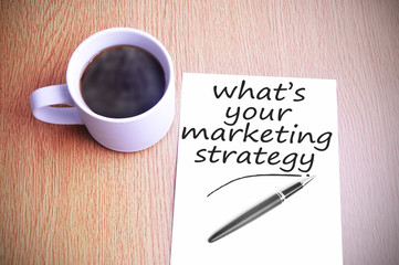 Coffee on the table with note writing whats your marketing strat