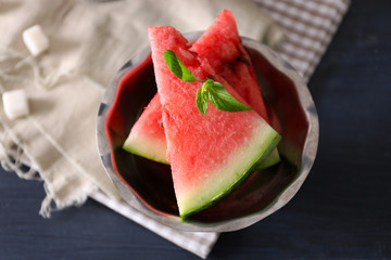Fresh sliced watermelon in a bowl on decorated background