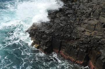 Waves crashing on volcanic cliffs.
