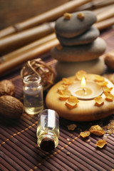 Decorated composition with candles and pebbles on bamboo mat, close up