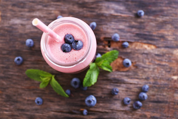 Healthy strawberry yogurt with mint and berries around on wooden background