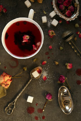 Cup of rose tea with sugar on wooden table