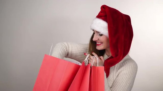 Woman in santa claus hat with shopping bags 4K