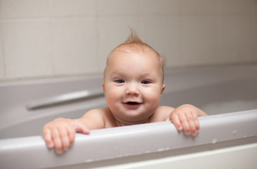 smile  kid looks out of  bathroom, bathing in  bathroom