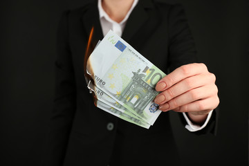 Woman burning Euro banknotes closeup