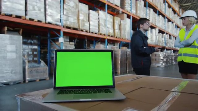 Laptop with Green Screen in Logistics Warehouse. Great for Mock-up usage. Shot with RED Epic