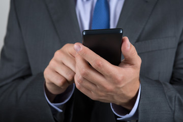 Close up of business man hands holding mobile phone