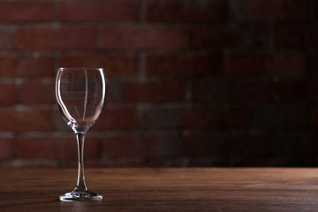 Empty wine glasses on a table on a brick wall background