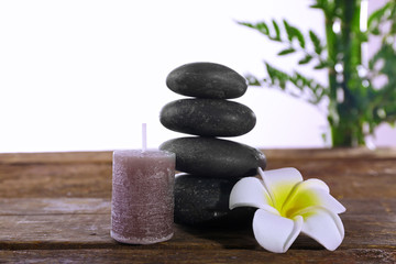 Fototapeta na wymiar Spa stones, a candle and a lotus, isolated on white