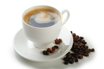 A cup of tasty drink and scattered coffee grains, isolated on white