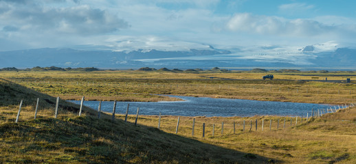 Fototapeta premium Lonely car with small lake and snow mountain background in Autumn season