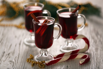 Mulled wine with cookies on wooden table