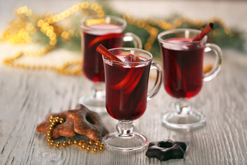 Mulled wine with cookies on wooden table