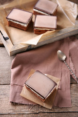Delicious chocolate brownies on tray, on wooden background