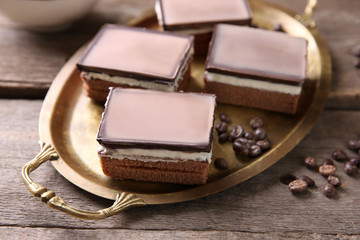 Delicious chocolate brownies on tray, on wooden background